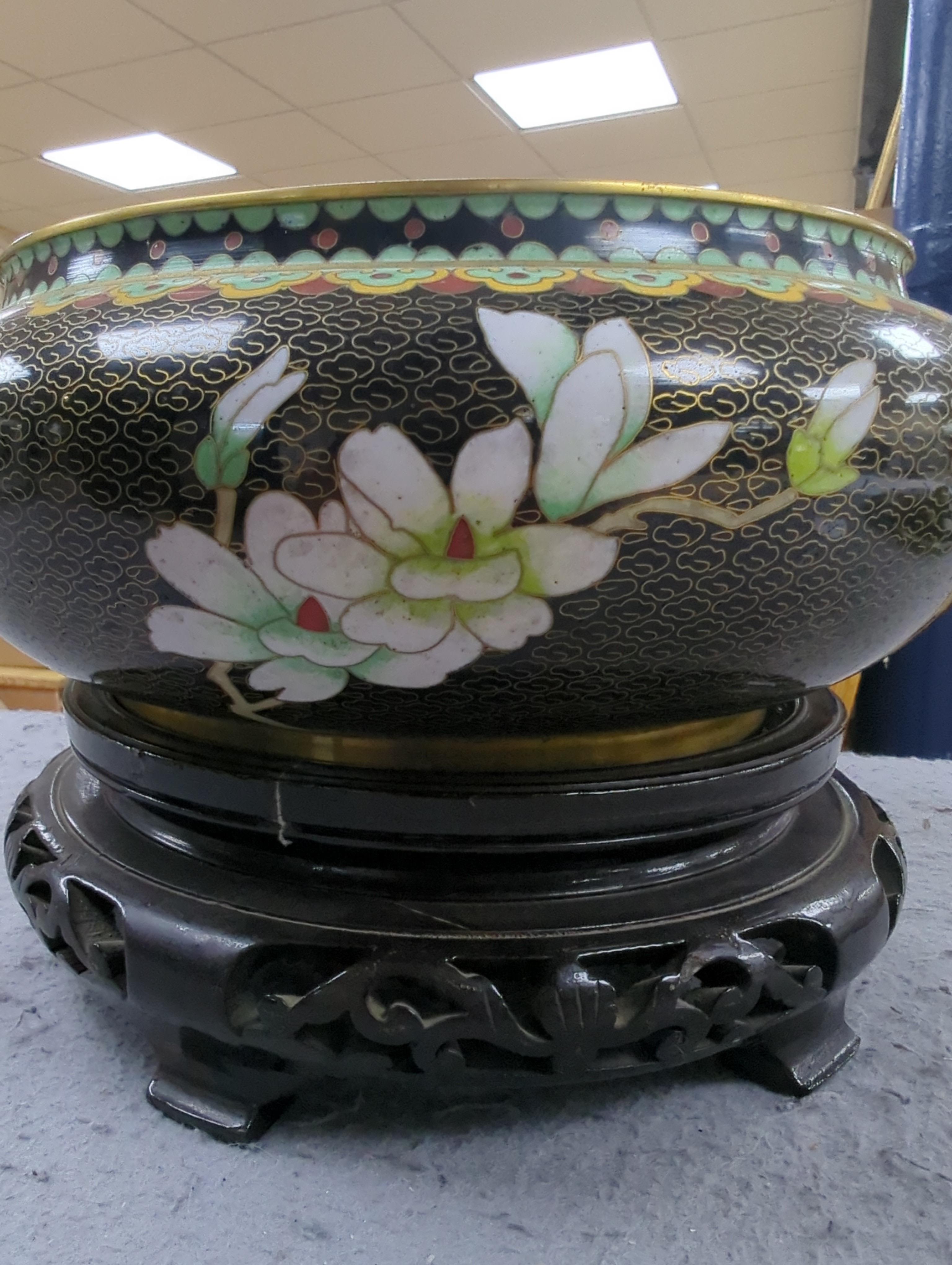 A Chinese cloisonné enamel three footed vase and cover together with a censer and cover, each raised on hardwood stands, the largest 26cm in diameter